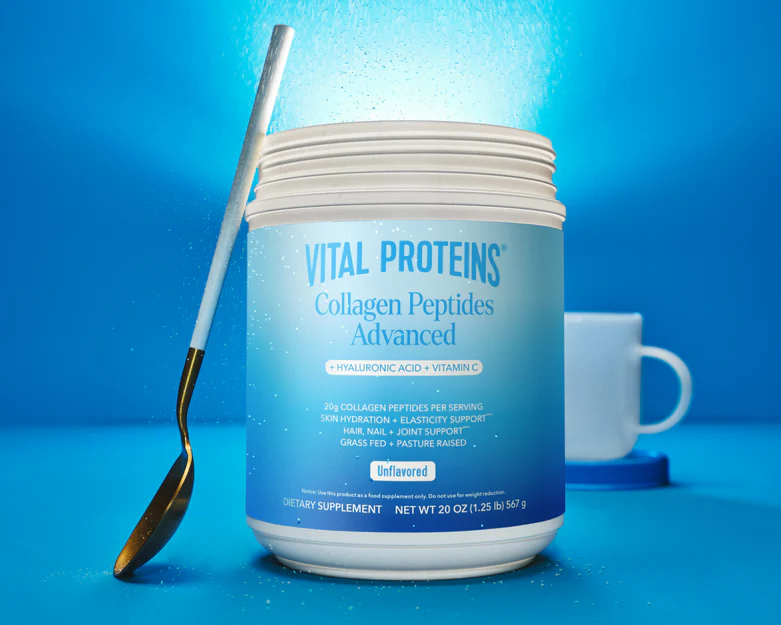 Vital Proteins collagen peptides blue tub on a white marble counter with a glass of water