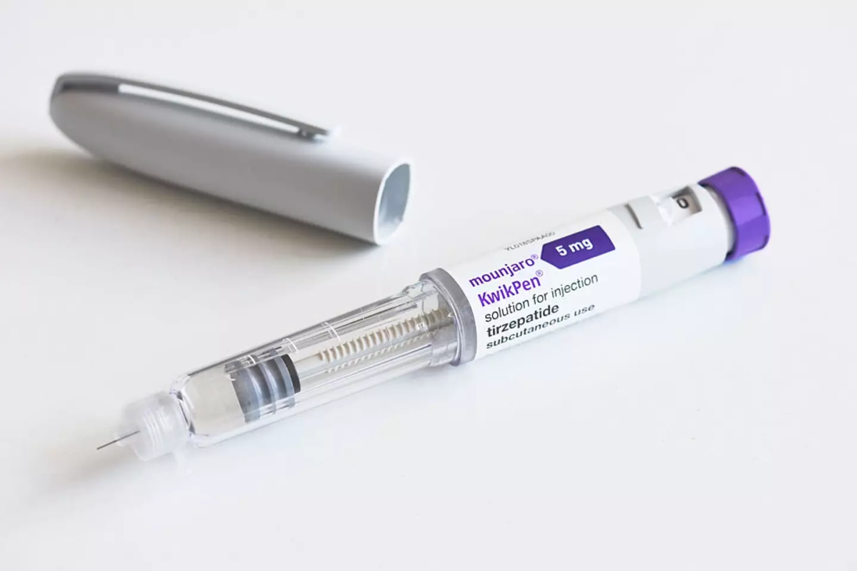 A Mounjaro KwikPen placed next to a stethoscope representing pharmacy price check options