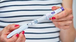 Medical professional holding a Mounjaro KwikPen to explain dosage and cost